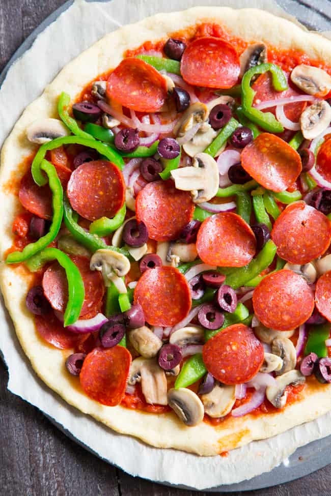 This paleo pepperoni pizza is loaded with all your favorite veggies and packed with flavor!  It's baked on the perfect paleo pizza crust and is totally dairy free, gluten free, grain free and soy free.  This healthy pizza is family approved and easy to make, too! 