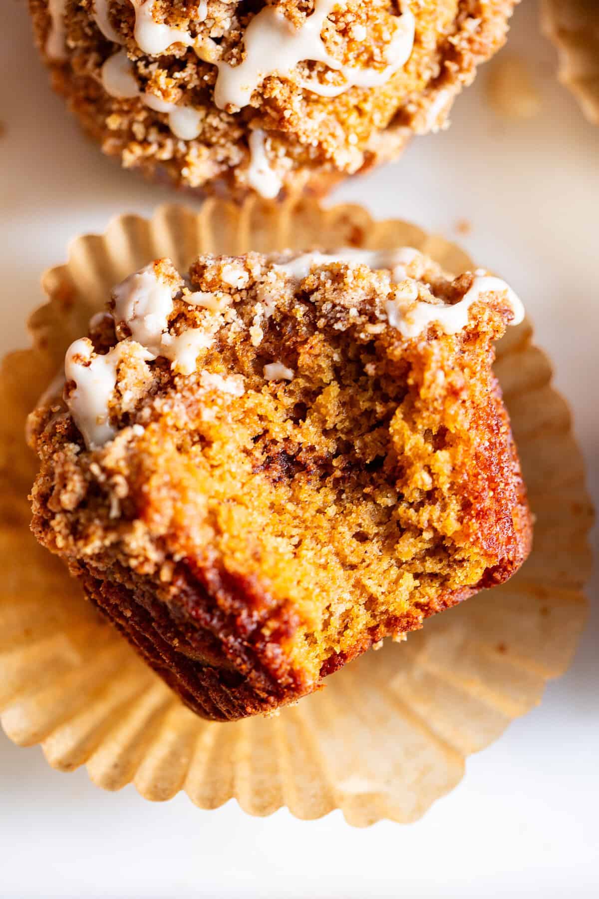 Almond flour pumpkin muffin topped with cinnamon streusel showing crumb texture inside