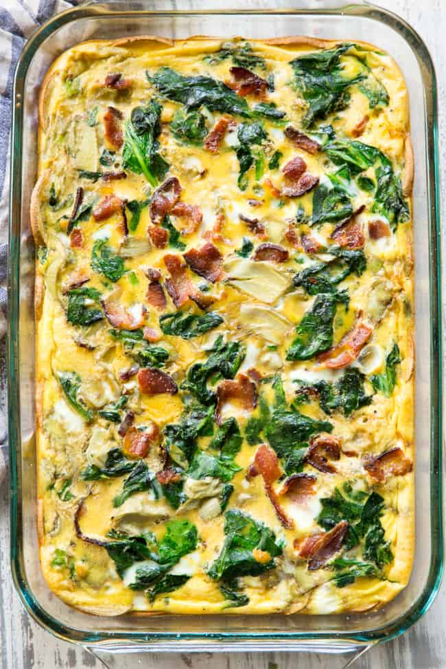 This spinach artichoke breakfast casserole starts with an easy roasted sweet potato crust and is loaded with veggies, bacon, and flavor!  Dairy-free, grain free, gluten free, paleo and Whole30 compliant.  It's perfect to make ahead of time for easy, satisfying breakfast all week