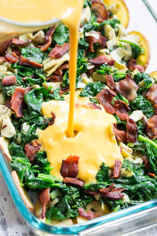 This spinach artichoke breakfast casserole starts with an easy roasted sweet potato crust and is loaded with veggies, bacon, and flavor!  Dairy-free, grain free, gluten free, paleo and Whole30 compliant.  It's perfect to make ahead of time for easy, satisfying breakfast all week