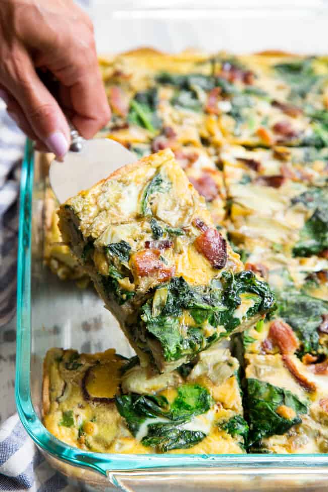 This spinach artichoke breakfast casserole starts with an easy roasted sweet potato crust and is loaded with veggies, bacon, and flavor!  Dairy-free, grain free, gluten free, paleo and Whole30 compliant.  It's perfect to make ahead of time for easy, satisfying breakfast all week