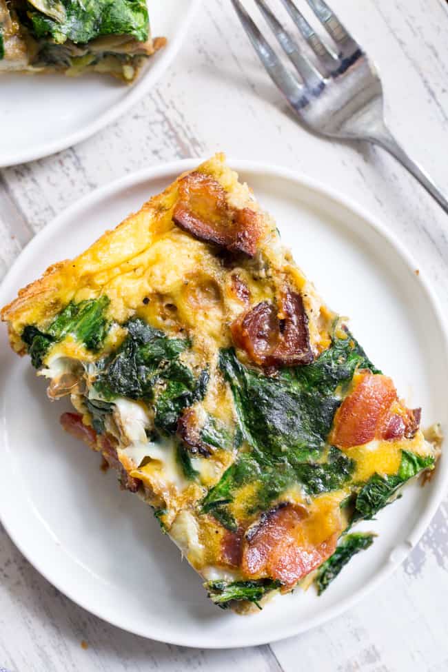 This spinach artichoke breakfast casserole starts with an easy roasted sweet potato crust and is loaded with veggies, bacon, and flavor!  Dairy-free, grain free, gluten free, paleo and Whole30 compliant.  It's perfect to make ahead of time for easy, satisfying breakfast all week