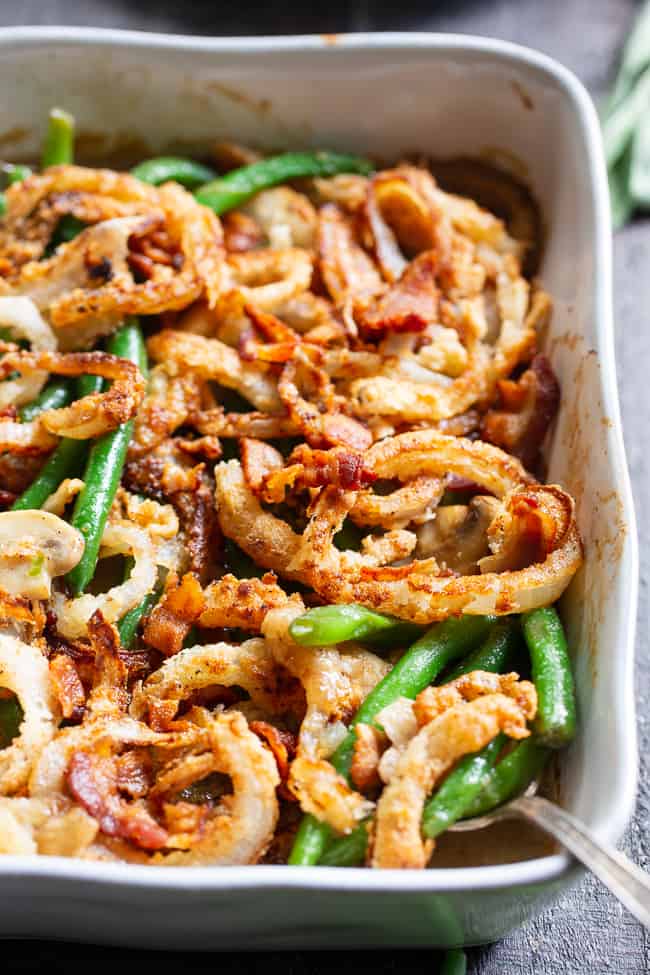 green beans with bacon and fried crispy onions in a white scalloped casserole dish