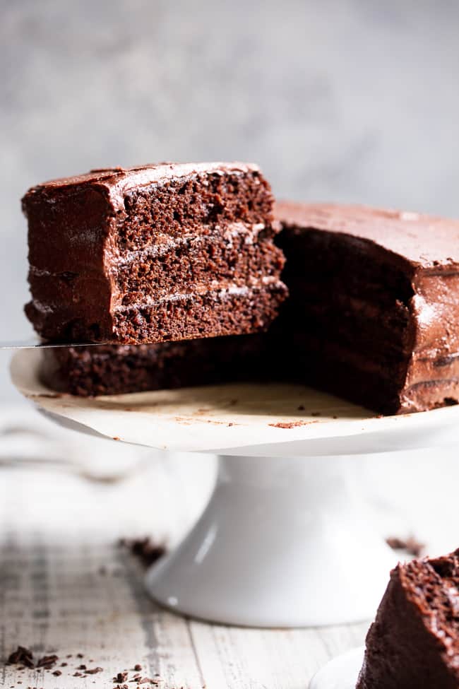 This rich, decadent, moist and tender paleo chocolate cake is made healthier with a blend of grain free flours, organic coconut oil and unrefined coconut sugar.  The dairy-free “buttercream” frosting is out of this world delicious and NONE of it tastes paleo, even though it totally is!  Paleo dessert. Paleo cake. Paleo birthday. Paleo baking. Paleo treats. Paleo chocolate.