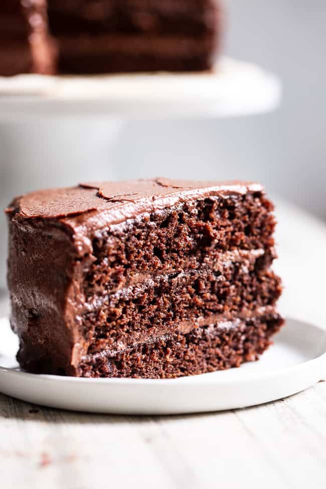 This rich, decadent, moist and tender paleo chocolate cake is made healthier with a blend of grain free flours, organic coconut oil and unrefined coconut sugar.  The dairy-free “buttercream” frosting is out of this world delicious and NONE of it tastes paleo, even though it totally is!  Paleo dessert. Paleo cake. Paleo birthday. Paleo baking. Paleo treats. Paleo chocolate.
