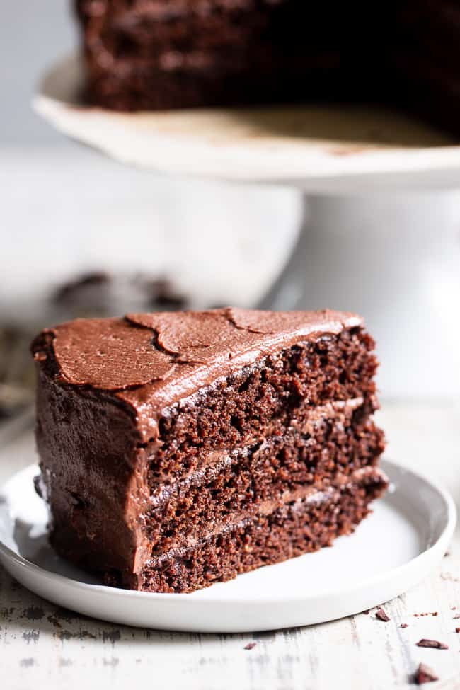 This rich, decadent, moist and tender paleo chocolate cake is made healthier with a blend of grain free flours, organic coconut oil and unrefined coconut sugar.  The dairy-free “buttercream” frosting is out of this world delicious and NONE of it tastes paleo, even though it totally is!  Paleo dessert. Paleo cake. Paleo birthday. Paleo baking. Paleo treats. Paleo chocolate.