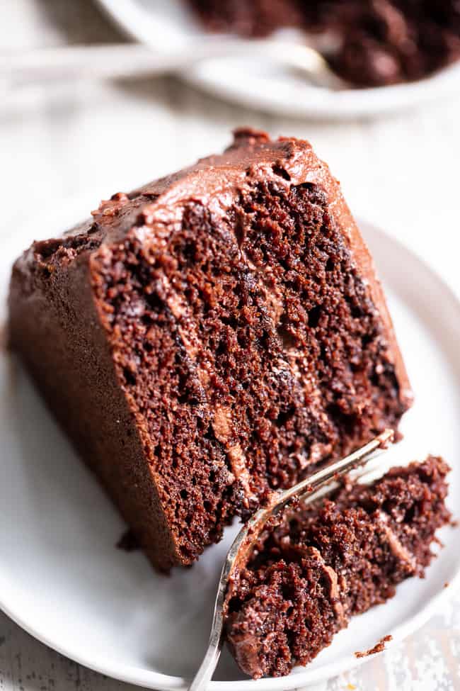 This rich, decadent, moist and tender paleo chocolate cake is made healthier with a blend of grain free flours, organic coconut oil and unrefined coconut sugar.  The dairy-free “buttercream” frosting is out of this world delicious and NONE of it tastes paleo, even though it totally is!  Paleo dessert. Paleo cake. Paleo birthday. Paleo baking. Paleo treats. Paleo chocolate.