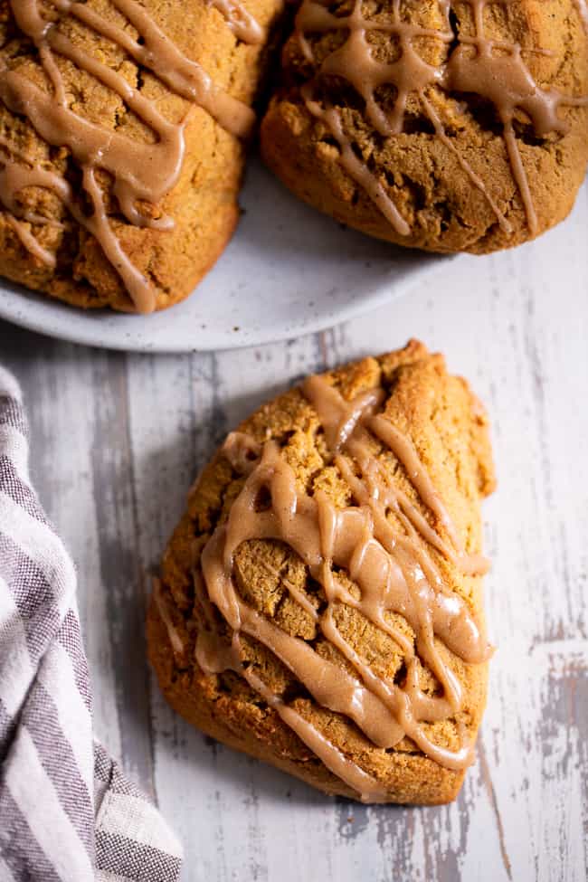 These paleo pumpkin scones are tender and full of pumpkin spice flavor!  Serve them warm topped with a pumpkin spice drizzle for a special (healthier!) treat this fall.  Gluten free and paleo with dairy-free options.  Paleo baking. Paleo desserts. Paleo scones. Paleo Pumpkin recipes.