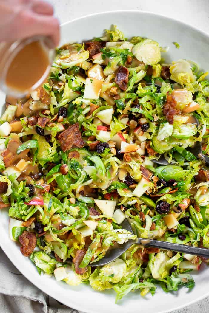 This shredded Brussels sprouts salad is loaded with so many delicious things!  Sweet chopped apples, crispy bacon, toasted hazelnuts and a sweet tangy apple vinaigrette.  It’s paleo, dairy-free, with a Whole30 option and perfect for a crowd or as a make ahead lunch.