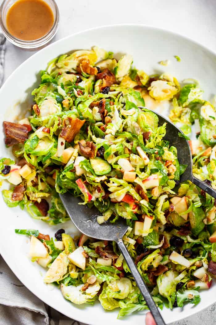 This shredded Brussels sprouts salad is loaded with so many delicious things!  Sweet chopped apples, crispy bacon, toasted hazelnuts and a sweet tangy apple vinaigrette.  It’s paleo, dairy-free, with a Whole30 option and perfect for a crowd or as a make ahead lunch.