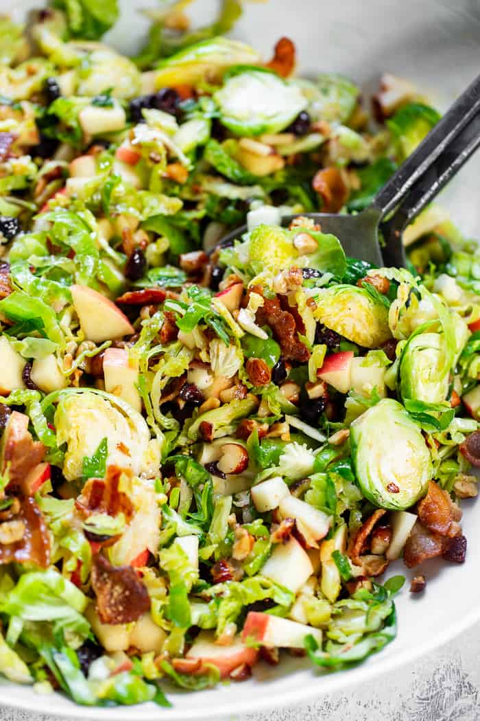 This shredded Brussels sprouts salad is loaded with so many delicious things!  Sweet chopped apples, crispy bacon, toasted hazelnuts and a sweet tangy apple vinaigrette.  It’s paleo, dairy-free, with a Whole30 option and perfect for a crowd or as a make ahead lunch.