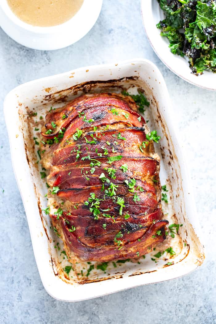 This bacon wrapped meatloaf is the ultimate comfort food!  It’s smothered in a savory mushroom gravy and you won’t believe it’s actually good for you.  Paleo, dairy-free, Whole30 compliant and keto friendly.