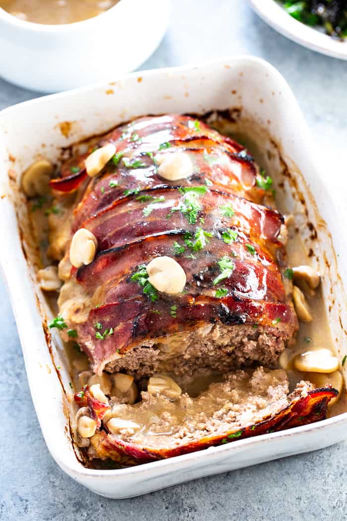 This bacon wrapped meatloaf is the ultimate comfort food!  It’s smothered in a savory mushroom gravy and you won’t believe it’s actually good for you.  Paleo, dairy-free, Whole30 compliant and keto friendly.