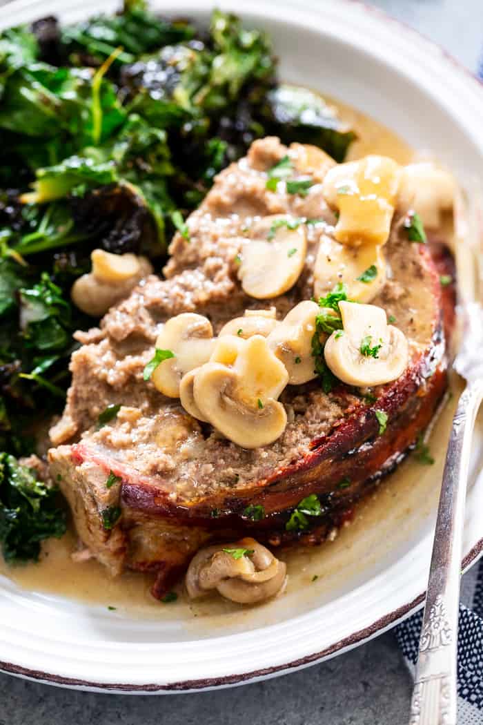 This bacon wrapped meatloaf is the ultimate comfort food!  It’s smothered in a savory mushroom gravy and you won’t believe it’s actually good for you.  Paleo, dairy-free, Whole30 compliant and keto friendly.