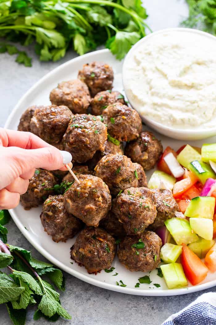 These easy greek meatballs are perfectly flavorful and delicious dipped in a dairy-free paleo Tzatziki sauce!   Great as an appetizer or as part of a meal over a greek salad.  Paleo, Whole30, and keto friendly.