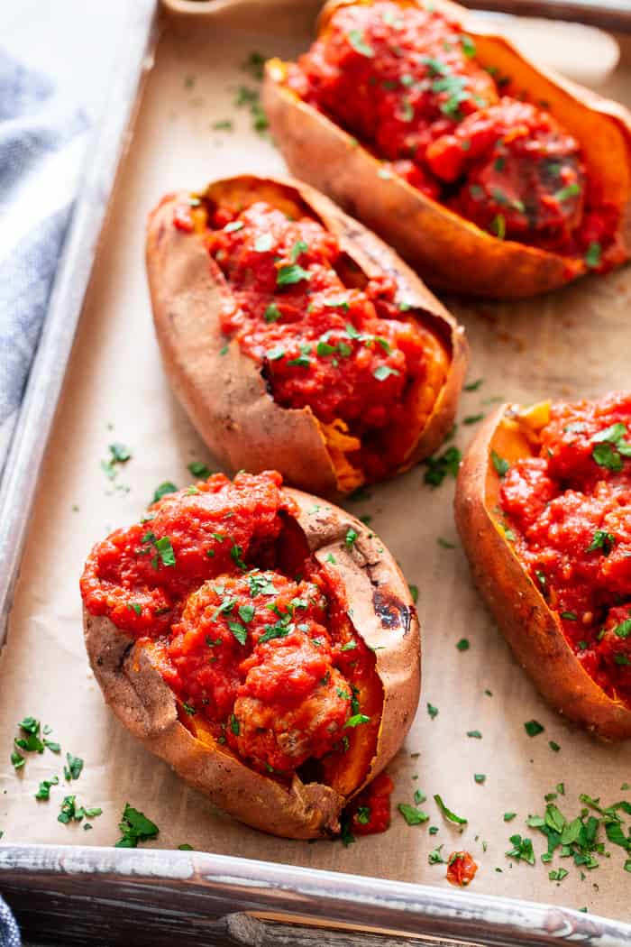 These Italian Meatball Stuffed Sweet Potatoes are flavor packed and easy to make!  Quick and easy pan fried Italian meatballs are simmered in sauce and served over perfectly baked sweet potatoes for a paleo and Whole30 meal that’s filing and addicting! 