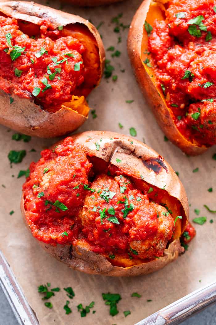 These Italian Meatball Stuffed Sweet Potatoes are flavor packed and easy to make!  Quick and easy pan fried Italian meatballs are simmered in sauce and served over perfectly baked sweet potatoes for a paleo and Whole30 meal that’s filing and addicting! 