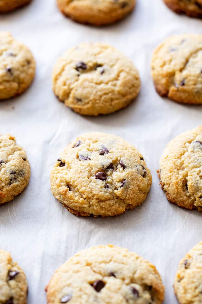 a baking sheet lined with parchment paper with rows of softly baked cookies