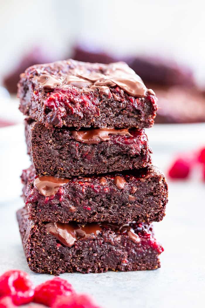 These insanely fudgy raspberry brownies are easy to whip up and just happen to be good for you!  Rich chocolate paleo and vegan brownie batter is baked with an easy raspberry sauce for the ultimate fruit and chocolate combo.  They’re gluten-free, dairy-free, and completely addicting!