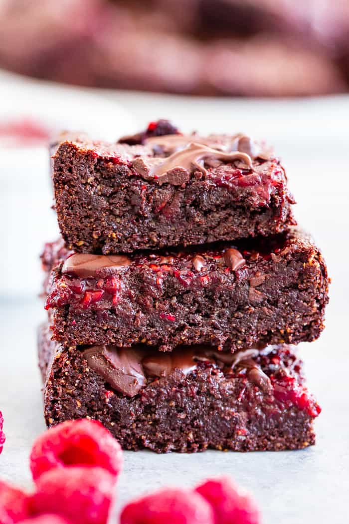 These insanely fudgy raspberry brownies are easy to whip up and just happen to be good for you!  Rich chocolate paleo and vegan brownie batter is baked with an easy raspberry sauce for the ultimate fruit and chocolate combo.  They’re gluten-free, dairy-free, and completely addicting!