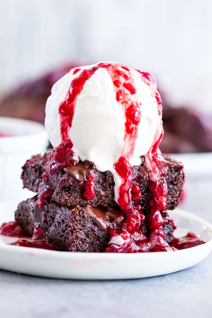 These insanely fudgy raspberry brownies are easy to whip up and just happen to be good for you!  Rich chocolate paleo and vegan brownie batter is baked with an easy raspberry sauce for the ultimate fruit and chocolate combo.  They’re gluten-free, dairy-free, and completely addicting!