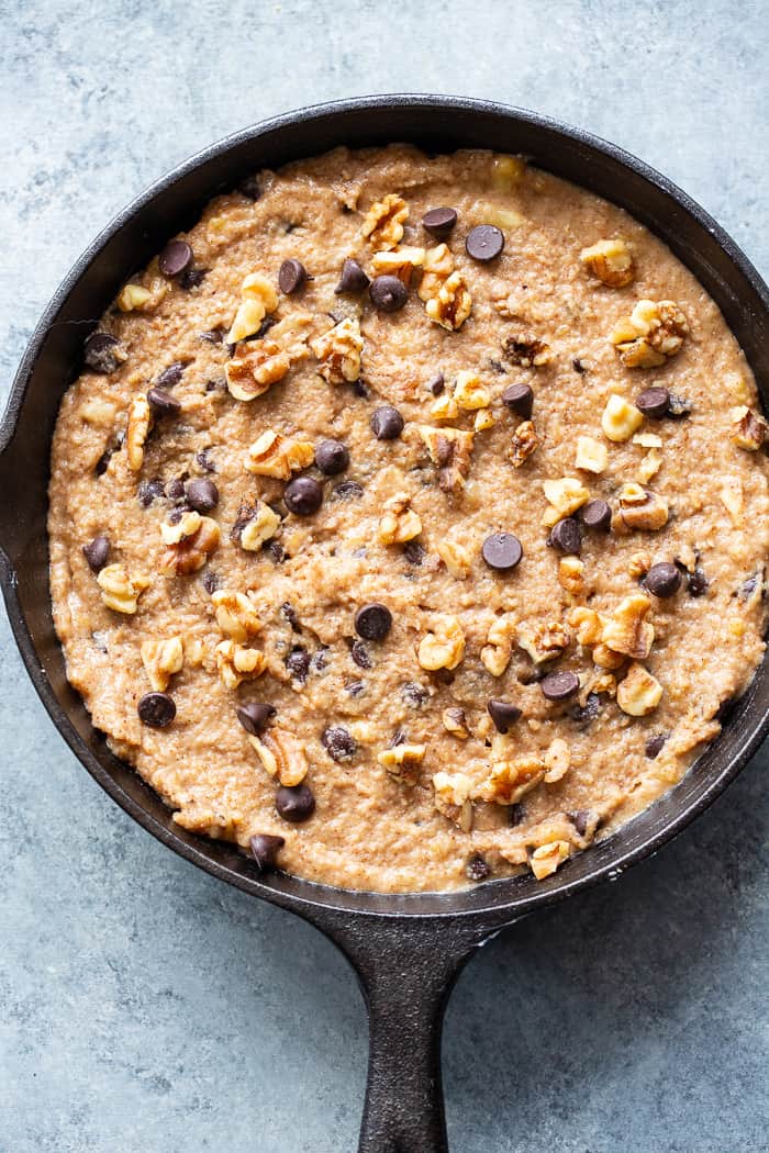 This banana gooey chocolate chip skillet cookie is a dessert that’s heathy enough for breakfast!  It’s loaded with healthy fats, sweetened with bananas and unrefined maple sugar and packed with dark chocolate chips and walnuts.  Gluten-free, grain free, paleo, dairy free, and vegan too!