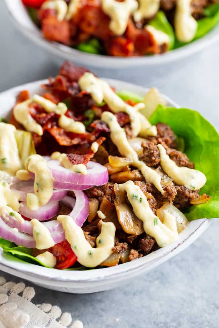 These deconstructed loaded bacon burger bowls have all the goodies you love in a burger!  Sautéed mushrooms and onions, crispy bacon, pickles, tomatoes, red onion and a “cheesy” ranch sauce!  Paleo, Whole30, and keto friendly and seriously delicious!