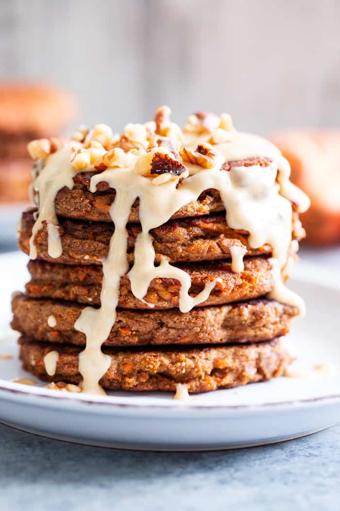 These fluffy, sweet spiced carrot cake pancakes have a dairy-free drizzle that tastes just like a cream cheese icing!  They're made with coconut flour and sweetened with coconut sugar for a healthier take on a Spring breakfast treat.  Gluten-free, dairy-free, refined sugar free, and paleo friendly.