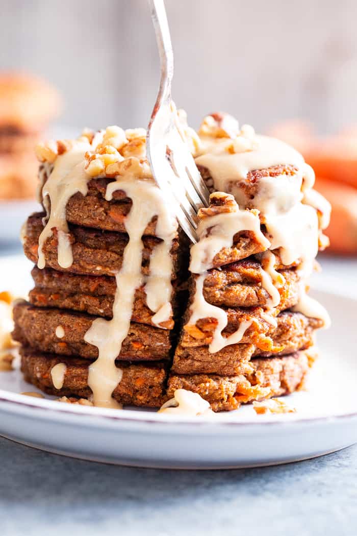 These fluffy, sweet spiced carrot cake pancakes have a dairy-free drizzle that tastes just like a cream cheese icing!  They're made with coconut flour and sweetened with coconut sugar for a healthier take on a Spring breakfast treat.  Gluten-free, dairy-free, refined sugar free, and paleo friendly.