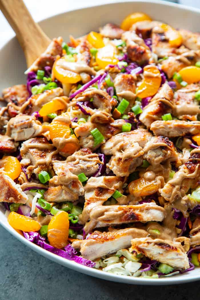 closeup photo of Chinese chicken salad drizzled with almond butter sesame dressing