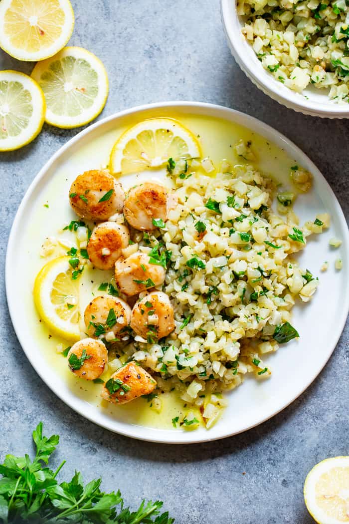 Pan seared scallops are taken to the next level with a lemon garlic “butter” sauce that’s made with ghee instead of butter.  Served with a simple herbed cauliflower rice, this quick and easy dinner is full of flavor, low carb, keto Paleo, and Whole30 compliant.