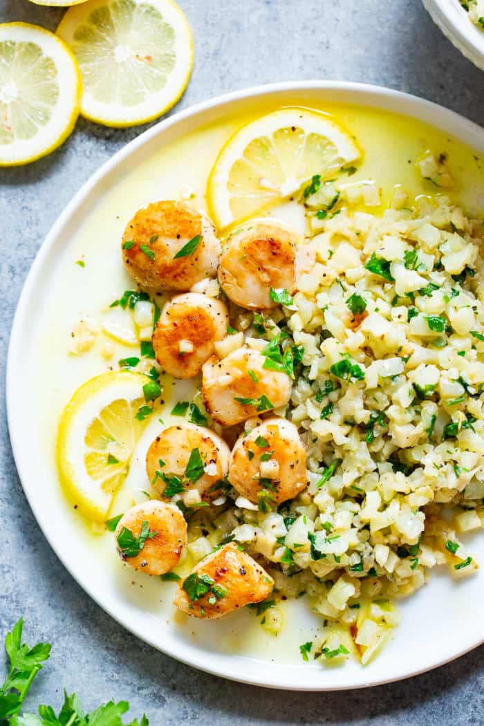 Pan seared scallops are taken to the next level with a lemon garlic “butter” sauce that’s made with ghee instead of butter.  Served with a simple herbed cauliflower rice, this quick and easy dinner is full of flavor, low carb, keto Paleo, and Whole30 compliant.