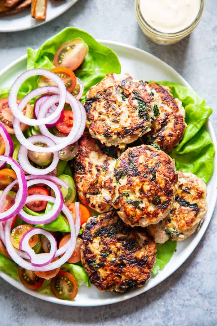 These chicken burgers are packed with veggies and tons of flavor!  A savory spinach artichoke mixture is added to the burgers before they’re grilled and topped with more goodies!  Whole30, paleo, and keto friendly.  A healthy way to break out of your burger rut!