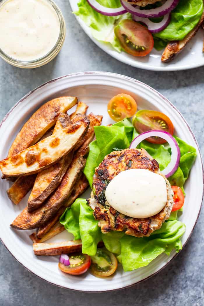 These chicken burgers are packed with veggies and tons of flavor!  A savory spinach artichoke mixture is added to the burgers before they’re grilled and topped with more goodies!  Whole30, paleo, and keto friendly.  A healthy way to break out of your burger rut!