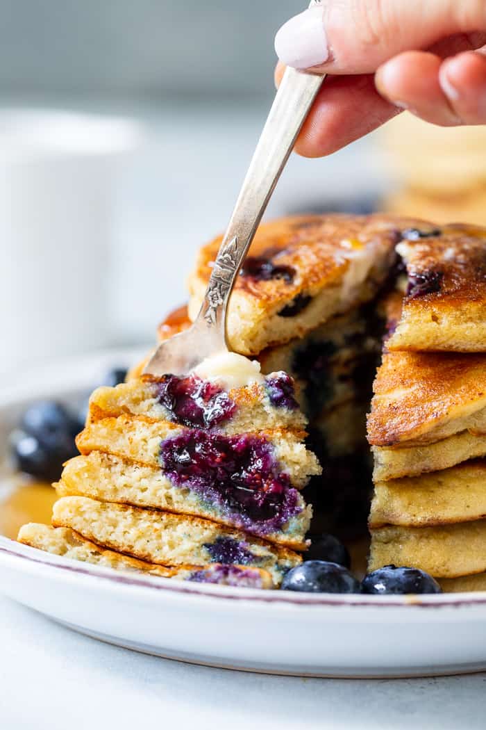 These fluffy paleo buttermilk blueberry pancakes are the perfect healthy answer to your pancake cravings! They come together quickly and are a hit with kids and adults alike. Grain free, nut free, dairy free and freezable, which makes them great for breakfast or brunch anytime!