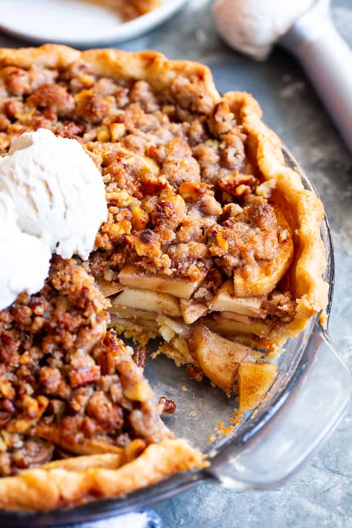 an apple pie with crumble topping and a scoop of ice cream on top