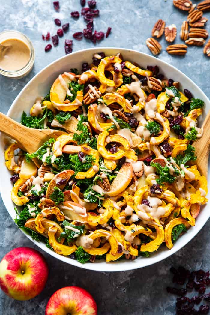This harvest kale salad is packed to the max with goodies!  Perfectly roasted delicata squash, apples, pecans, and cranberries all tossed in a cider vinaigrette that’s naturally sweetened with dates.  Whole30, Paleo, vegan, and no refined sugar.