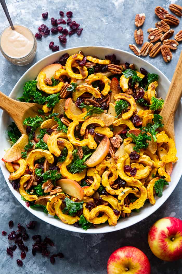 This harvest kale salad is packed to the max with goodies!  Perfectly roasted delicata squash, apples, pecans, and cranberries all tossed in a cider vinaigrette that’s naturally sweetened with dates.  Whole30, Paleo, vegan, and no refined sugar.