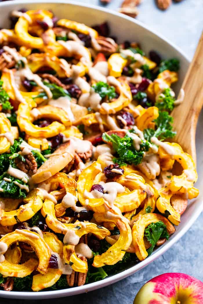 This harvest kale salad is packed to the max with goodies!  Perfectly roasted delicata squash, apples, pecans, and cranberries all tossed in a cider vinaigrette that’s naturally sweetened with dates.  Whole30, Paleo, vegan, and no refined sugar.