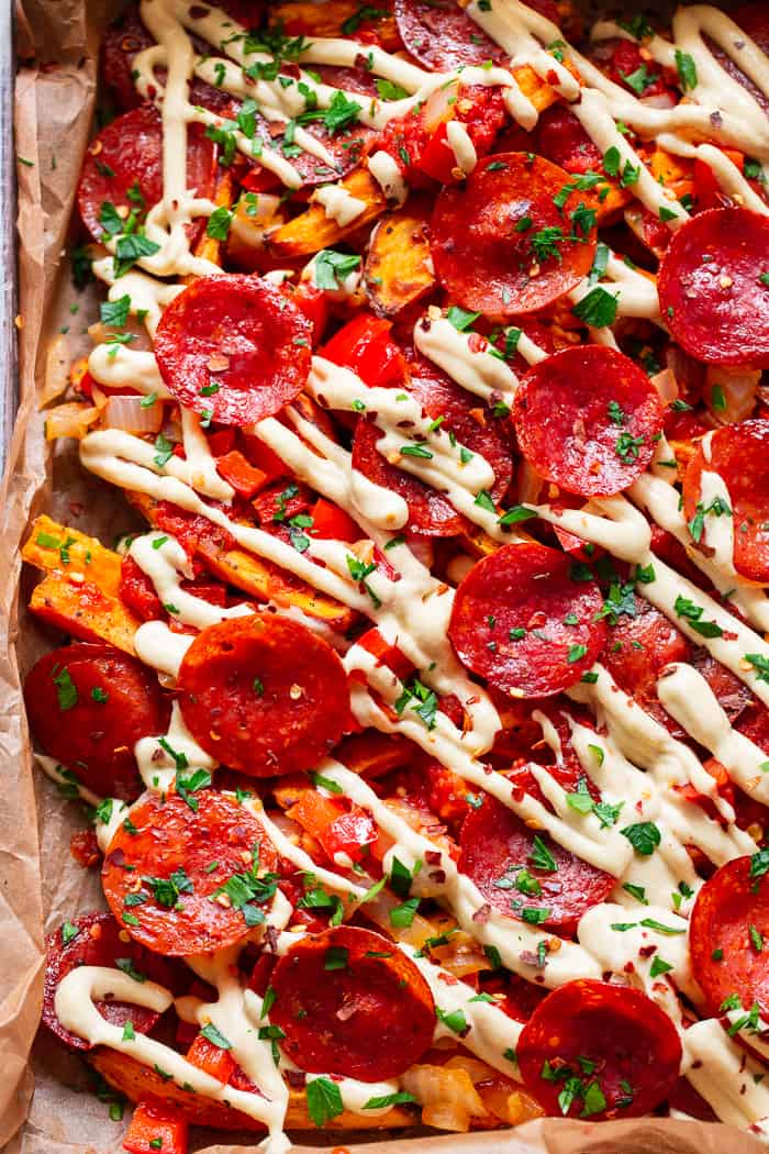 These loaded sweet potato fries have all the toppings to make you feel like you’re eating a pepperoni pizza!  An easy dairy free cheese sauce, marinara, peppers and onions, and zesty pepperoni make this a fun meal that’s just as healthy as it is delicious!  Paleo, gluten-free, dairy-free, family friendly.