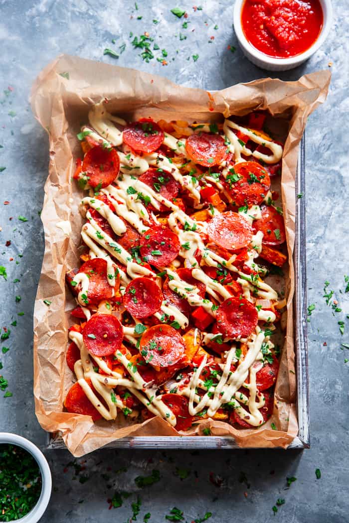 These loaded sweet potato fries have all the toppings to make you feel like you’re eating a pepperoni pizza!  An easy dairy free cheese sauce, marinara, peppers and onions, and zesty pepperoni make this a fun meal that’s just as healthy as it is delicious!  Paleo, gluten-free, dairy-free, family friendly.