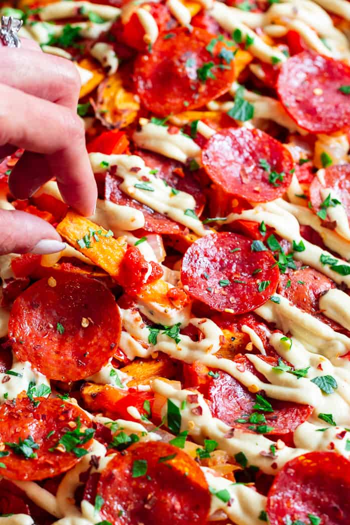 These loaded sweet potato fries have all the toppings to make you feel like you’re eating a pepperoni pizza!  An easy dairy free cheese sauce, marinara, peppers and onions, and zesty pepperoni make this a fun meal that’s just as healthy as it is delicious!  Paleo, gluten-free, dairy-free, family friendly.