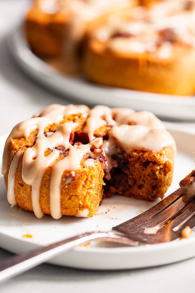pumpkin cinnamon roll with maple icing on a plate
