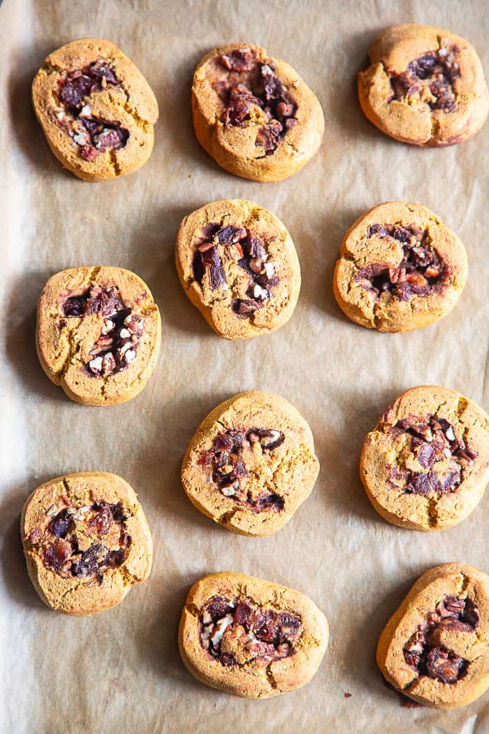 pumpkin cinnamon rolls on parchment paper before icing
