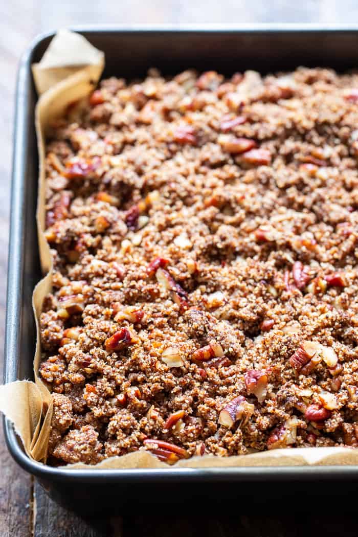 cake with brown chopped pecan crumble topping in a gray square pan