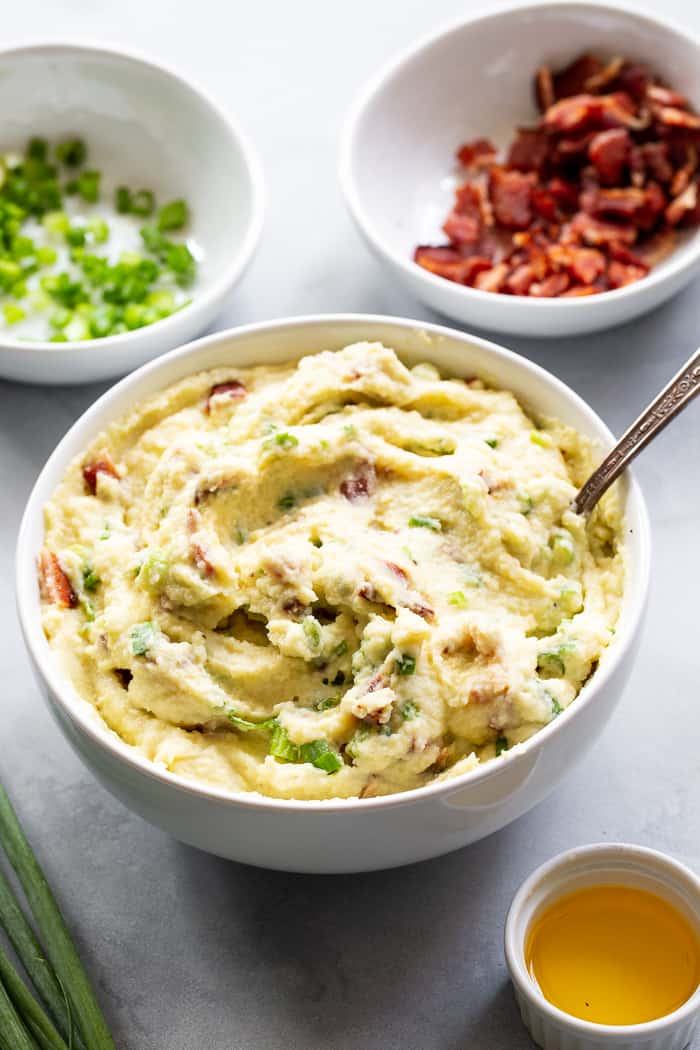 This creamy mashed cauliflower is packed with goodies like roasted garlic, crispy bacon and scallions. It tastes just like loaded mashed potatoes, but without the carbs!  Whole30 compliant, paleo, keto, and dairy-free.