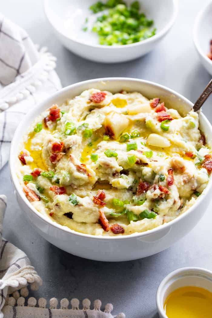 This creamy mashed cauliflower is packed with goodies like roasted garlic, crispy bacon and scallions. It tastes just like loaded mashed potatoes, but without the carbs!  Whole30 compliant, paleo, keto, and dairy-free.