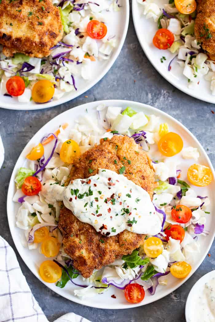 This savory crisp Paleo Chicken Milanese topped with zesty homemade ranch sauce is a quick and easy dinner you’ll want on repeat!  Serve over a salad, spaghetti squash, roasted veggies, or anything you like.  It’s Whole30, Keto friendly, gluten free and dairy free.