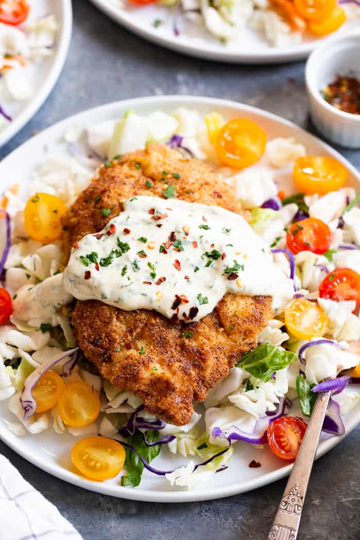 This savory crisp Paleo Chicken Milanese topped with zesty homemade ranch sauce is a quick and easy dinner you’ll want on repeat!  Serve over a salad, spaghetti squash, roasted veggies, or anything you like.  It’s Whole30, Keto friendly, gluten free and dairy free.