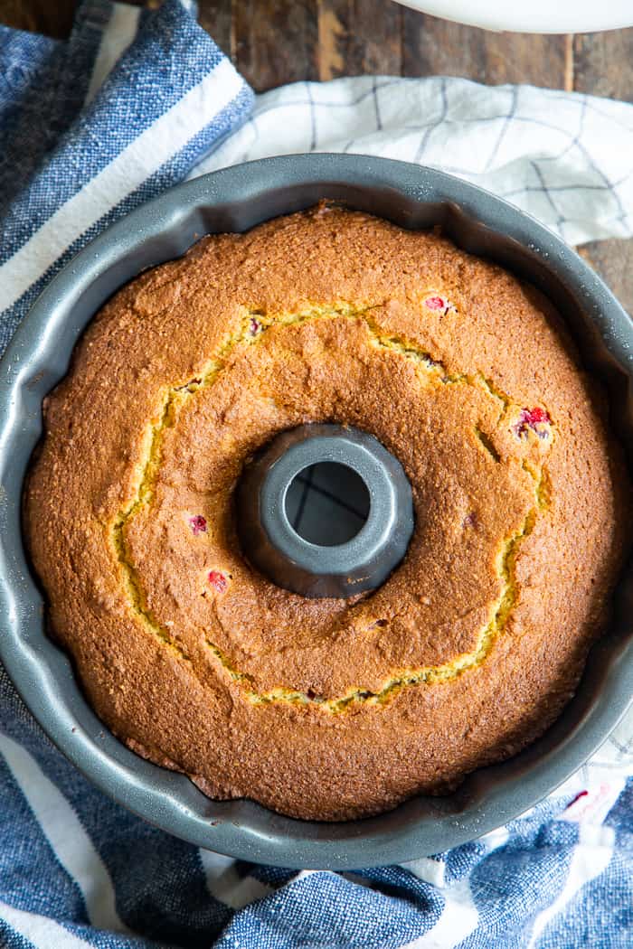 This Paleo Cranberry Orange Bundt Cake is perfectly moist  bursting with sweet orange flavor and tart juice cranberries.  A cinnamon swirl plus sweet maple glaze make this bundt cake a holiday showstopper!  It’s gluten-free, grain free, refined sugar free and has a dairy-free option. 